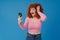 European smiling woman with red curly hair using mobile phone