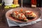 European Spanish cuisine. Baked eggplants with meat and vegetables, parmesan cheese. White wine on the table. Close-up background