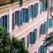 European style windows with wooden shutters. Building exterior.