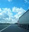 European truck vehicle on motorway with blue sky and white clouds.