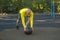 European-type man is doing push-ups with a medicine ball on a street sports ground.