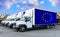 European Union flag on the back of Five new white trucks against the backdrop of the river and the city. Truck, transport, freight