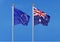 European Union vs Australia. Thick colored silky flags of European Union and Argentina. 3D illustration on sky background. -