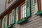 European windows with green wooden shutters in old house. Outdoo