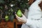 European woman check riping lemons on te tree in greenhouse