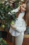 European woman check riping lemons on te tree in greenhouse