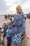 European woman dressed long sand protective dress and headscarf sitting on the camel while riding in the Sahara desert in Tunisia