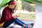 European woman in a tent overlooking the forest  holds a telephone in her hands. A modern holiday with devices