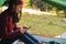 European woman in a tent overlooking the forest  holds a telephone in her hands. A modern holiday with devices