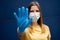 European woman wearing protective face mask, outstretched hand with protection glove as stop symbol. Corona virus