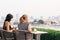 European women sitting and watching a view of Wat Arun The Temple of Dawn near Chaophraya River in the evening at the rooftop.