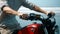 European young man hold motorbike handlebars while touching gas handle and brake lever ahead of trip