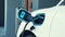 EV charger from home charging station recharging electric car. Peruse