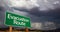 Evacuation Route Green Road Sign and Stormy Clouds