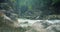 Evaporation over a cold mountain river with clear water in rocky gorge. Spring nature landscape.