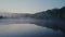 Evaporation of water above a lake in the forest in the early hours of the morning.