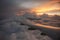 Evening flight over storm clouds. Flight during a storm. View of the beautiful sunset from the plane window