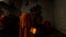 Evening Hindu ceremony automatic Aarti machine plays monk in orange clothes rings in bell and lights lamp with big wick statue of