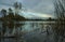 Evening landscape. Lake, cloudy sky reflections on the water. Dramatic clouds.