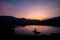 Evening landscape mountains river blue sky There was a thin orange cloud after sunset. And there is a man\'s shadow sitting