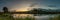 evening landscape. panoramic view of the sunset from the coast of a narrow river overgrown with reeds