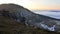 Evening landscape with tall open-cast quarry mine, pit benches and ramps clearly visible, dense fog in background.