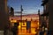 Evening light and sky colors between urban buildings with messy powerlines running across and stop signs on street below