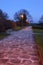 Evening path with lit lamps and paved floor