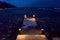 Evening pier in floating ice in a winter lake, warm lights