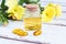 Evening primrose oil in bottle, pills and flowers on wooden table, Oenothera biennis essence