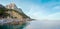 Evening rocky coastline panorama and old lighthouse on slope (Sokol rock, Novyj Svit coast, Crimea, Ukraine