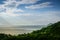 Evening sea landscape with sun rays and green wooded coast.