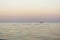 Evening sea with waves, far away on a horizon line floating ship, nature abstract background