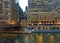 Evening sets over a bridge with reflections of lights on the Chicago River.