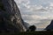 Evening shot of beautiful fjord valley, surrounded by mountains, cloudy blue skies