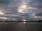 Evening sky with dark rainclouds and fiery sunlight reflections at Findhorn Bay, Scotland