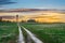 Evening sky at sunset road in the field leading to the shed barn and water tower of the rural landscape of the village.