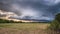 Evening storms over a hay field