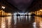 Evening streets of the old town with bright orange lanterns reflecting off the wet cobblestones in the rain with fog and
