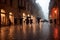 Evening streets of the old town with bright orange lanterns reflecting off the wet cobblestones in the rain with fog and