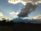 Evening sun behind beautiful large clouds over dark fields