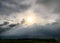 Evening sun throwing beams around storm clouds