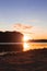 Evening sunset lighting dramatic picturesque landscape with sand beach and river shore, unfocused concept of island silhouette on