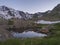 Evening sunset summer view from Bremer Hutte with lake from melting snow tongues and snow-capped moutain peaks, lush