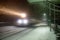 Evening train arrives at station. Snowfall