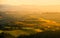 Evening in Tuscany. Hilly Tuscan landscape in golden mood at sunset time with silhouettes of cypresses and farm houses