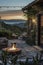 An evening view of a cozy outdoor seating area with a fire pit, surrounded by nature and a rustic building