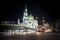 Evening view of the illuminated building of the Cathedral Mosque Madrasa, against the background of the evening sky, cars, tram