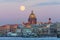 Evening view of the moon rising from the horizon and St. Isaac`s Cathedral in the city of St. Petersburg