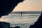 Evening view of surfers on the beach of Uluwatu framed by the rocks